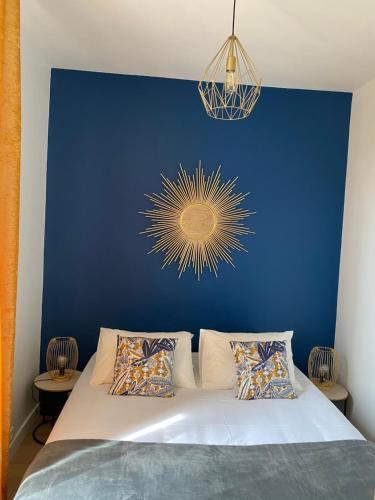 - une chambre dotée d'un mur bleu et d'un lit avec des oreillers dans l'établissement Villa st Louis 2, à Cabourg