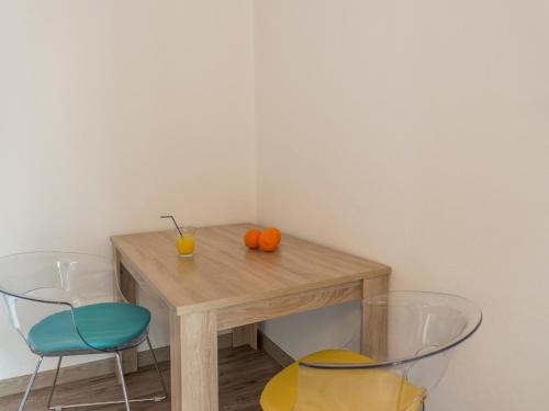 a table with two chairs and two oranges on it at Apartments Windrose in Kotor