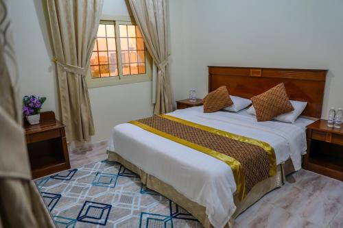 a bedroom with a large bed and a window at الارجوان الراقية in Yanbu