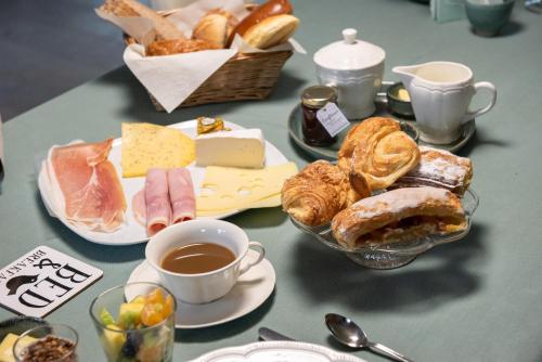 a table topped with plates of food and a cup of coffee at B&B Hof Beygaert in Aalst