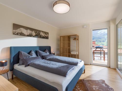 1 dormitorio con 1 cama con cabecero azul en Appartment am Sonnberg en Brixen im Thale
