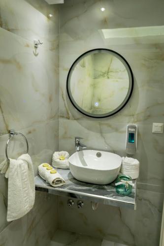 a bathroom with a sink and a mirror at Family Inn Apartments&suites in Neos Marmaras