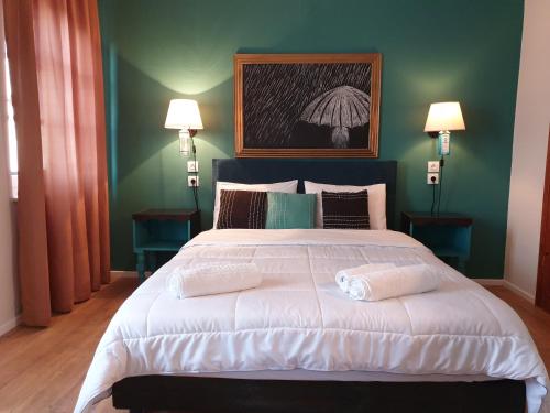 a bedroom with a large white bed with two lamps at Aigaion Guesthouse in Therma