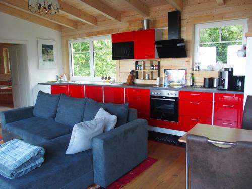 sala de estar con sofá azul y armarios rojos en Schwedenhaus Eichenberg, en Eichenberg