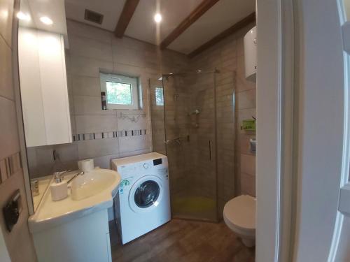 a bathroom with a washing machine and a washer at Letnia Ostoja Wieprz in Wieprz