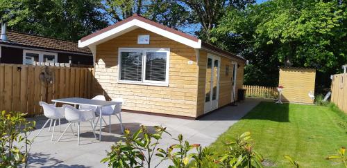 a small shed with a table and chairs in a yard at Rekerlanden 267 in Warmenhuizen