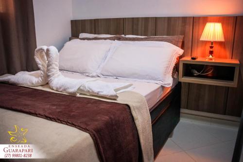 a bedroom with a bed with a towel on it at MAIOR NOTA - 2 Quartos com AR CONDICIONADOS SPLIT, Air Fryer, Wi-Fi, Disney Plus, Star Plus, HBO Max, Guarda Sol, Cadeiras de Praia, Caixa Térmica, Churrasqueira, Rede para Descanso e Chuveirão - 8 pessoas - CONFORTO Máximo - Melhor Localização!! in Guarapari