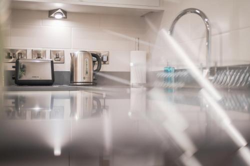 a kitchen with a counter top with a sink at The Knight Residence by Mansley in Edinburgh
