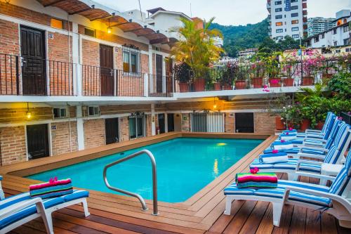 a swimming pool with lounge chairs on a deck at Hotel Posada De Roger in Puerto Vallarta