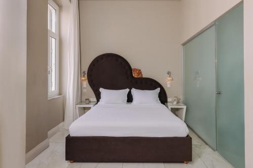 a bedroom with a large bed with a black headboard at 5 Hermoupolis Concept Sites in Ermoupoli