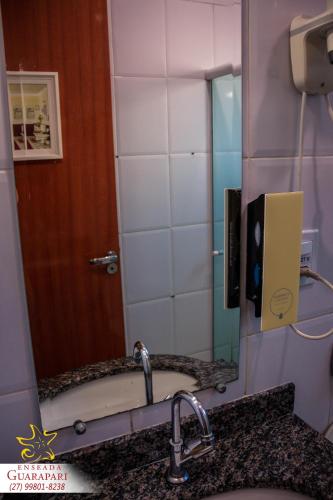 a bathroom mirror with a sink and a bath tub at MAIOR NOTA - 2 Quartos com AR CONDICIONADOS SPLIT, Air Fryer, Wi-Fi, Disney Plus, Star Plus, HBO Max, Guarda Sol, Cadeiras de Praia, Caixa Térmica, Churrasqueira, Rede para Descanso e Chuveirão - 8 pessoas - CONFORTO Máximo - Melhor Localização!! in Guarapari