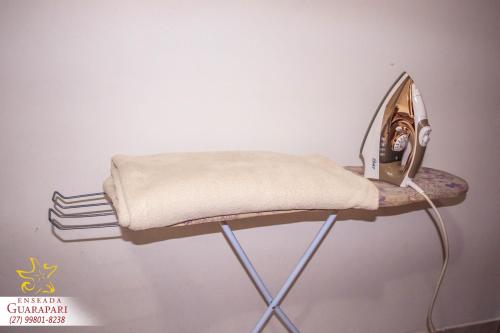 a shelf with a towel on a wall at MAIOR NOTA - 2 Quartos com AR CONDICIONADOS SPLIT, Air Fryer, Wi-Fi, Disney Plus, Star Plus, HBO Max, Guarda Sol, Cadeiras de Praia, Caixa Térmica, Churrasqueira, Rede para Descanso e Chuveirão - 8 pessoas - CONFORTO Máximo - Melhor Localização!! in Guarapari