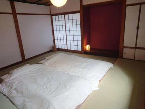 a large white bed in a room with windows at KINOSAKI KNOT - Vacation STAY 83611 in Toyooka
