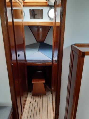 a small wooden cabinet with a bench in it at Privé B&B Motorsailer Rataplan in Kamperland