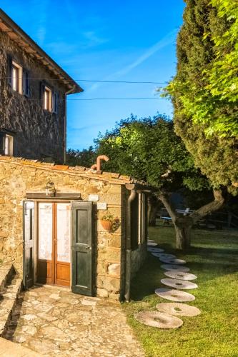a stone building with a door in a yard at Agriturismo La Sala in Greve in Chianti