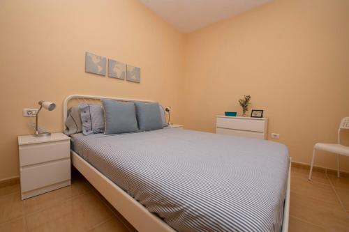 a bedroom with a large bed with blue pillows at Miramar 1 in San Sebastián de la Gomera