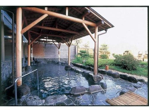 una piscina de agua bajo un pabellón en un patio en TOKINOSUMIKA HOTEL OLIVE NO KI - Vacation STAY 83624, en Izu