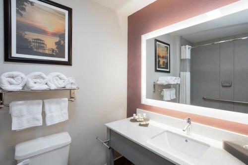 a bathroom with a sink and a mirror and a toilet at La Quinta by Wyndham Mobile - Daphne in Daphne