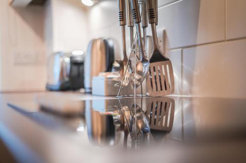a kitchen counter with spoons and utensils at The Knight Residence by Mansley in Edinburgh