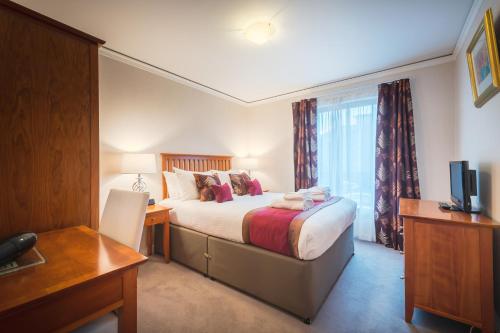 a bedroom with a bed with a desk and a window at The Knight Residence by Mansley in Edinburgh