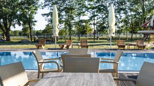 a group of chairs and tables next to a swimming pool at Hotel and Park Divoká Voda in Bratislava