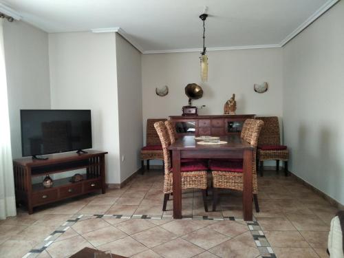 uma sala de estar com uma mesa e uma televisão em apartamento lahuerta em Bronchales
