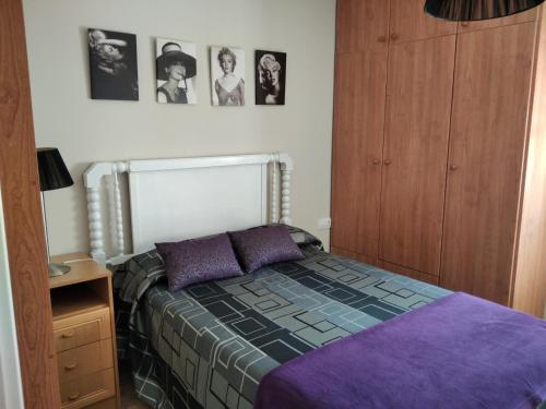 um quarto com uma cama e algumas fotografias na parede em apartamento lahuerta em Bronchales