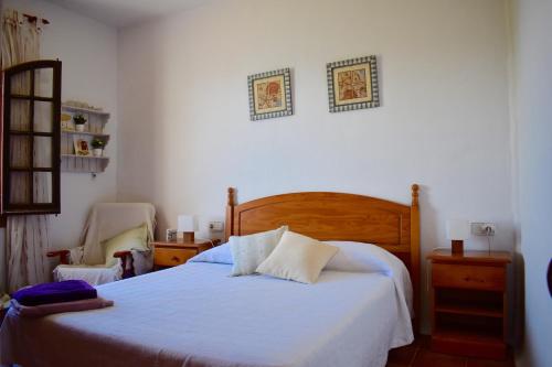 a bedroom with a bed and a chair at Apartamento en el mar con terraza in Fornells