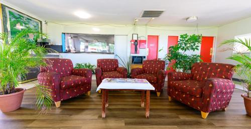 a waiting room with red chairs and a table at OAKS MOTEL GREENSBORO NC in Greensboro