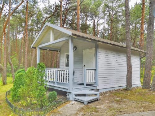 a tiny house with a porch in the woods at Mistral przy plaży Domki całoroczne in Ustka