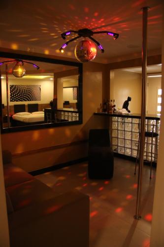 a living room with a couch and a mirror at Motel Hollywood in Salvador