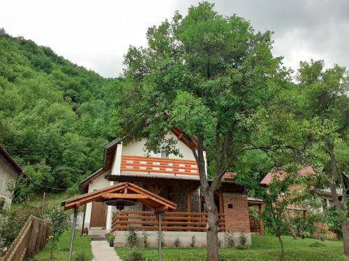una casa con un árbol delante de ella en Jovan, en Šipovo