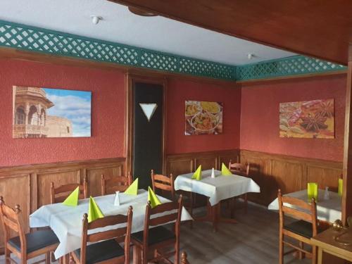 un restaurante con 2 mesas y sillas con servilletas amarillas en Hotel Granitz en Binz