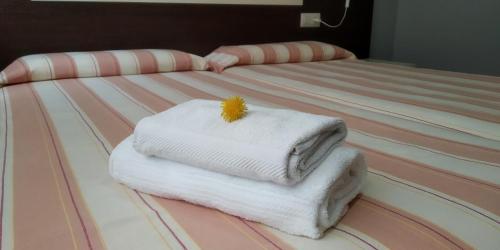 a stack of towels sitting on top of a bed at Apartaments La Farga Arbúcies in Arbúcies