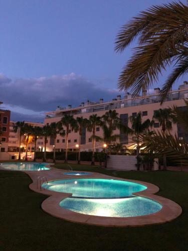 a group of three swimming pools in front of a building at Apartment Jardines y Mar in Denia