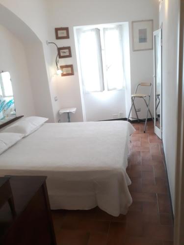 Cama blanca en habitación con ventana en Camere Francesca en Vernazza