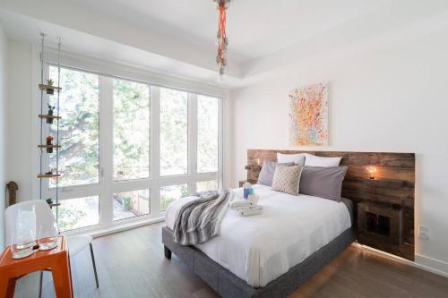 a bedroom with a bed and a large window at Elegant Downtown Home in Toronto