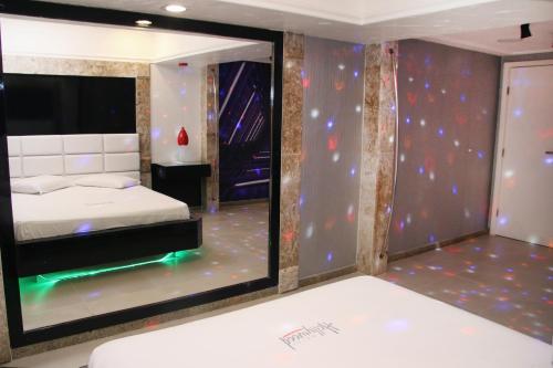1 dormitorio con cama y espejo grande en Motel Hollywood, en Salvador