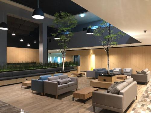 a lobby with couches and tables in a building at Holiday Inn Morelia by IHG in Morelia