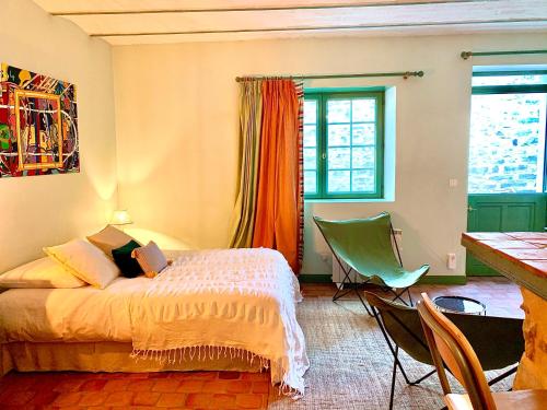 a bedroom with a bed and a table and chairs at La Pierre Levée in Montigny-sur-Loing