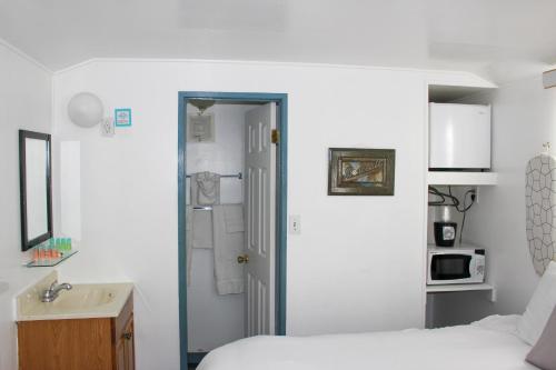 a bedroom with a bed and a bathroom with a sink at Hermosa Hotel in Avalon