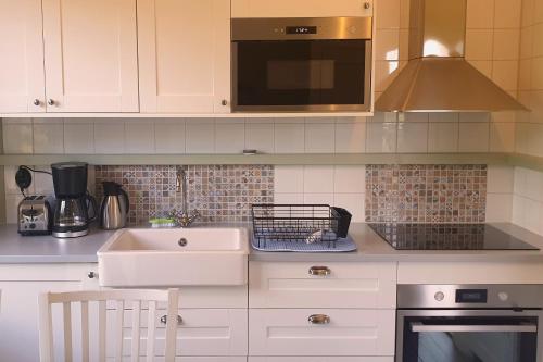 a kitchen with a sink and a microwave at Lilla Kari in Varberg