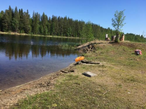 a lake with an orange object on the shore at Christinagården Guesthouse in Ramsele