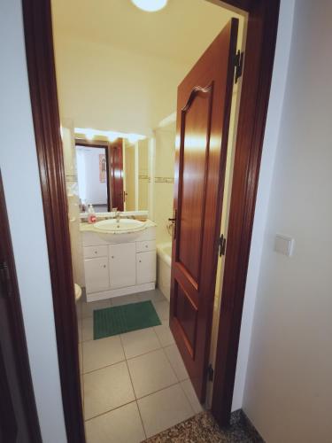 a bathroom with a sink and a toilet and a mirror at Ericeira Beach Haven in Ericeira