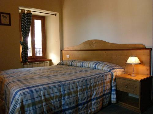 1 dormitorio con 1 cama y 1 mesa con lámpara en Rifugio Campiglio en Dumenza