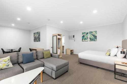 a living room with a bed and a couch at Presidential Motel in Mount Gambier