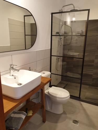 a bathroom with a toilet and a sink and a shower at Aigaion Guesthouse in Therma