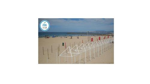 a beach with a row of poles in the sand at Casa de Praia in Costa da Caparica