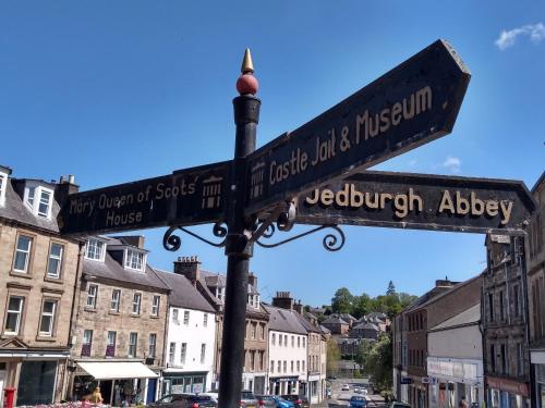 a street sign on a pole in a city at Marys Garden View South in Jedburgh