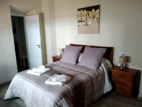 una camera da letto con un grande letto con due asciugamani di Apartamento Fregenal Centro R&S a Fregenal de la Sierra